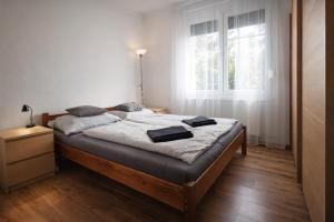 a bedroom with a bed and a window at Clarissa Apartman Eger in Eger
