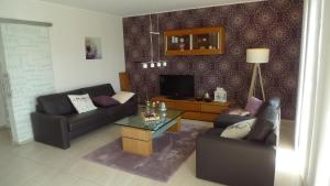 a living room with two couches and a television at Ferienhaus "Dorf-Glück" in Brilon