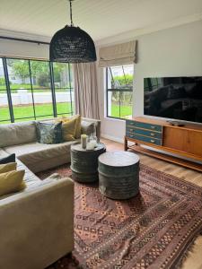 a living room with a couch and a tv at Dornoch House, Gowrie Village in Nottingham Road