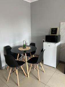 a dining room table with chairs and a small refrigerator at Cubes Ledig Luxury Apartments in Ledig +1 photo
