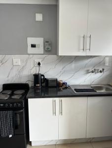 a kitchen with white cabinets and a black stove at Cubes Ledig Luxury Apartments in Ledig