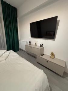 a bedroom with a bed and a flat screen tv on the wall at The Urban Line by D'or Selection in Bucharest