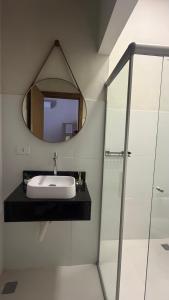 a bathroom with a sink and a mirror at Pousada Villa Peruaçu - Na entrada do Parque Nacional Cavernas Peruaçu in Januária