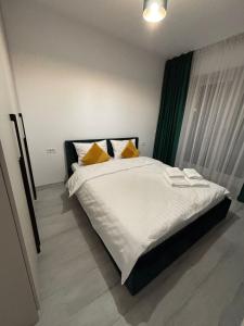 a bedroom with a large white bed with yellow pillows at The Urban Line by D'or Selection in Bucharest