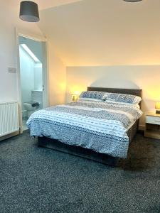a bedroom with a bed with a blue comforter at Salmon Leap Hotel in Whitby