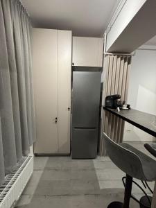 a room with a refrigerator and a table and a desk at The Urban Line by D'or Selection in Bucharest +7 photos