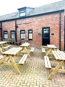 a group of picnic tables in front of a brick building at Salmon Leap Hotel in Whitby