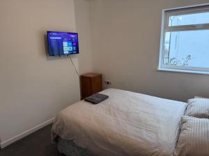a bedroom with a bed and a flat screen tv on the wall at King Street Rooms in Liverpool +3 photos