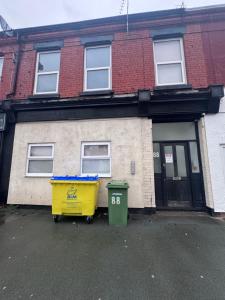 a house with a yellow recycling bin in front of it at King Street Rooms in Liverpool