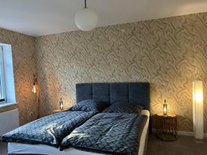 a bedroom with a blue bed with two night stands at Hostel Farm Ostedt in Wrestedt