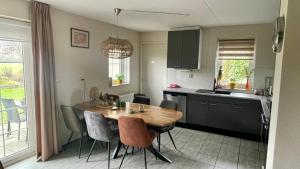 a kitchen with a wooden table and chairs in a room at Holiday Beach House Hellevoetsluis in Hellevoetsluis