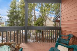 a porch with a green chair and a fence at Sun Song 3F in Fraser
