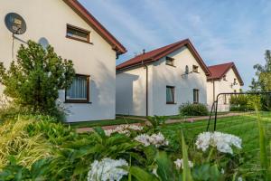 a house with a garden in front of it at Domki wczasowe AlexJan in Dąbki +11 photos