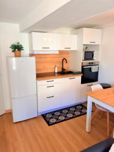 a kitchen with a white refrigerator and a table at Le Beau Dolois - Appartement Climatisé au Coeur de DOLE avec Parking GRATUIT à proximité in Dole +17 photos