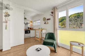 a living room with a green chair and a table at ღ La Bohème - avec Parking - Aéroport et Airbus in Blagnac