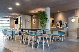 a restaurant with a blue table and chairs at Novotel Suites Nancy Centre in Nancy