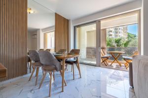 a dining room with a table and chairs and a balcony at AURA TOWER Apartments by Gaby in Rafailovici