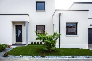 a white house with a green lawn at La casa del Platana in Domagné