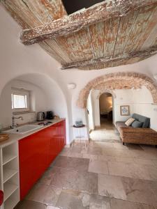 a kitchen with red cabinets and a large ceiling at Trullidea in Alberobello