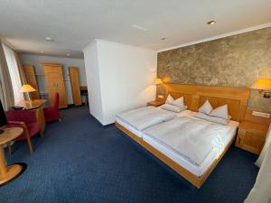 a hotel room with a bed and a table and chairs at Hotel gold Self-Check-In-Hotel Pfullendorf in Pfullendorf +19 photos