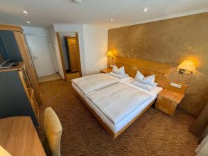 a bedroom with a large bed with white sheets at Hotel gold Self-Check-In-Hotel Pfullendorf in Pfullendorf