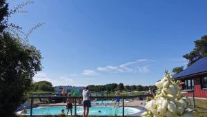 a group of people standing around a swimming pool at Stuga1-6 Dalskärs camping Badrum i Servicehus in Bergkvara