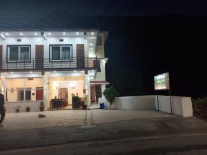 a house at night with a sign in front of it at Hotel Dharohar in Gopeshwar