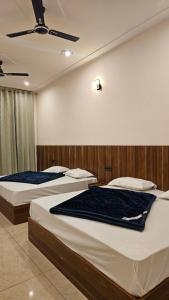 two beds in a hotel room with at Hotel Dharohar in Gopeshwar