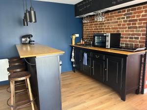a kitchen with a counter top and a microwave at La Petite Maison in Arsy