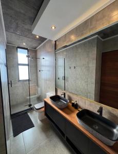 a bathroom with two sinks and a shower at The Concrete Edit in Benoni +43 photos