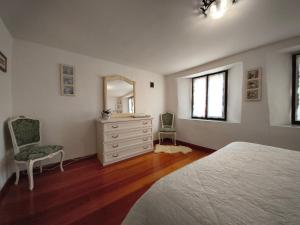 a bedroom with a bed and a dresser and a mirror at La casa nel borgo in Cavaso del Tomba