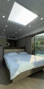 a large bed in a room with a large window at Kolsay tany in Kurmenty