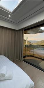 a bedroom with a bed and a large window at Kolsay tany in Kurmenty