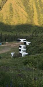 a group of benches in a field with a hill at Kolsay tany in Kurmenty