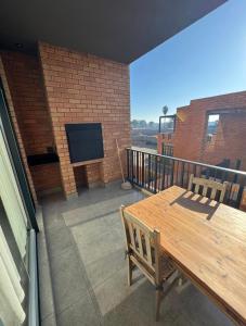 a patio with a table and a television on a balcony at The Concrete Edit in Benoni