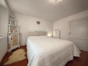 a bedroom with a bed with a white bedspread at La casa nel borgo in Cavaso del Tomba