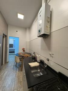 a kitchen with a sink and a table at Departamento Moderno, equipado en Vicente Lopez , Ideal River Plate ,Tecnópolis ,100 metros del tren in Vicente López