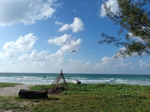 a kite flying over the ocean on a beach at Kudat Beach House 5 in Kudat