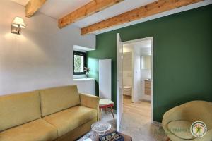 a living room with a couch and a green wall at Kerguntuil in Pleumeur-Bodou