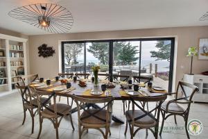 a dining room with a large table and chairs at Villa caroline in Trébeurden