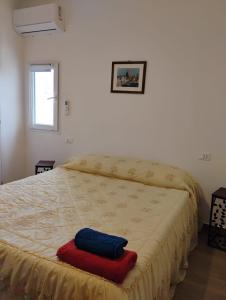a bed with a red and blue towel on it at Dentro Scopello - Casa Vacanze in Scopello