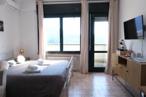a bedroom with a bed and a large window at Casa Segantini - Panorama Pool Apartment in Riva del Garda