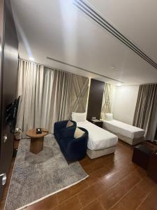 a hotel room with a bed and a couch and a table at ريف الشرقية للشقق الفندقية in Dammam
