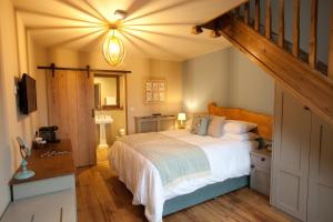 a bedroom with a bed and a stairway with a staircase at The Plough Inn in Stalisfield +33 photos