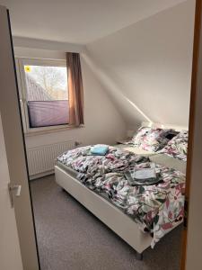 a bed in a small room with a window at Yunis Landhaus in Grömitz