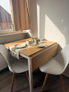 a wooden table with two chairs and two cups on it at Yunis Landhaus in Grömitz +13 photos