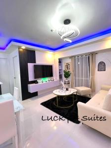 a living room with purple lights on the ceiling at Welcome to lucky7suites in Manila +20 photos