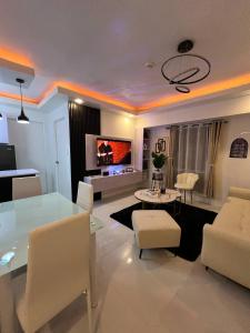 a living room with a glass table and white chairs at Welcome to lucky7suites in Manila
