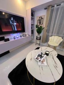 a living room with a tv and a white table at Welcome to lucky7suites in Manila