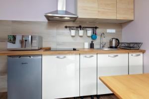 a kitchen with white cabinets and a counter top at Move&Rest Slunj in Slunj